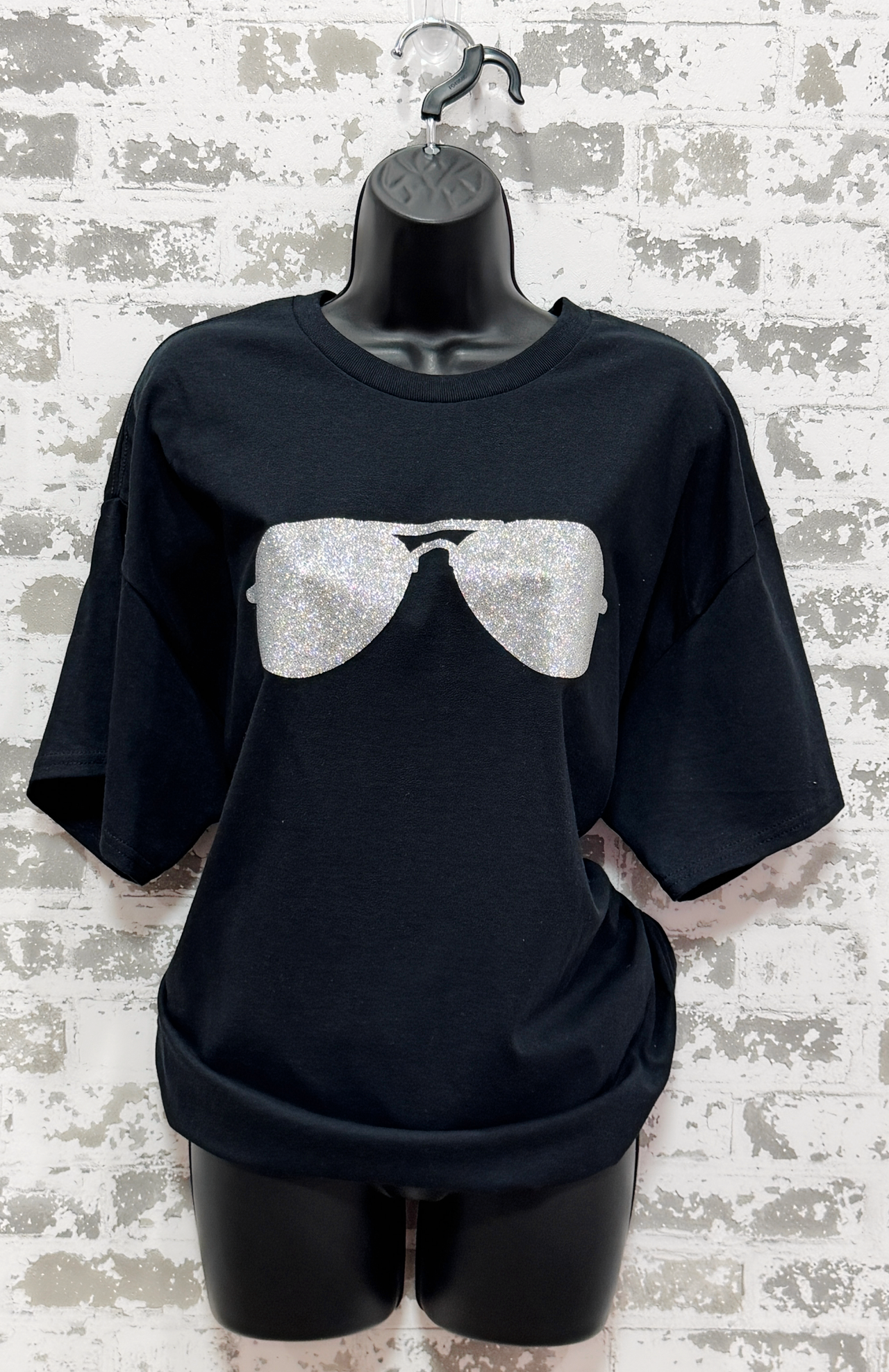 Black t-shirt with white sunglasses graphic on a textured white background