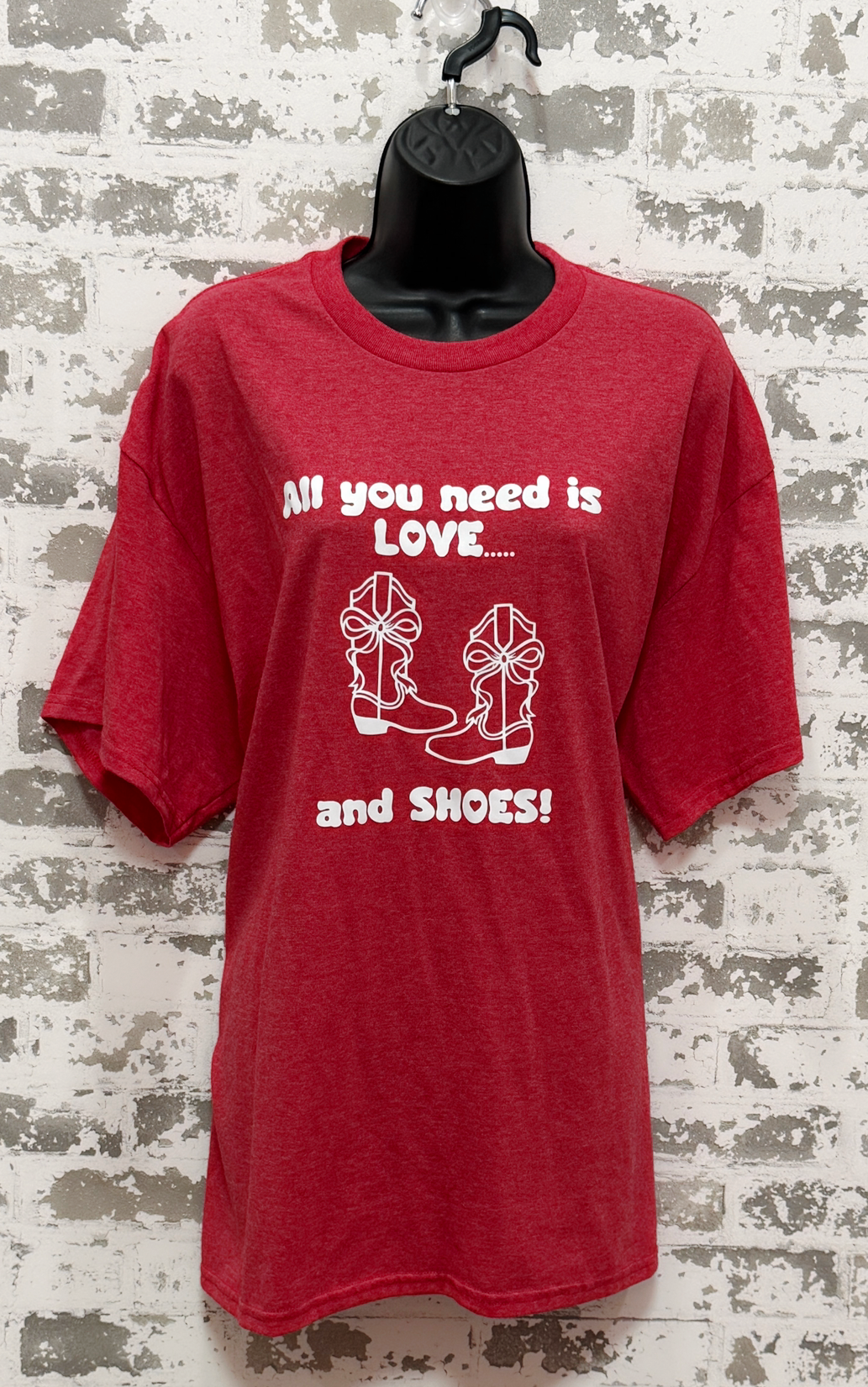 Red t-shirt with white text and graphics on a textured wall background
