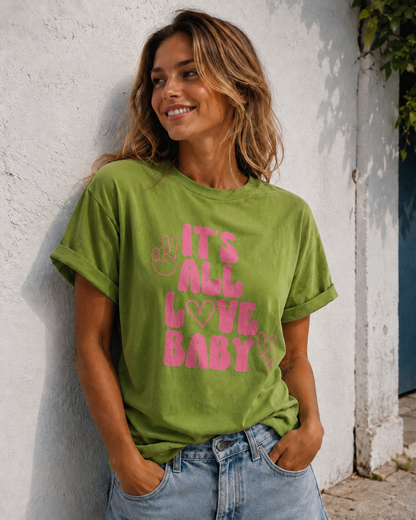 Woman wearing a green t-shirt with pink text against a white wall.