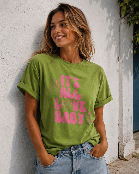 Woman wearing a green t-shirt with pink text against a white wall.