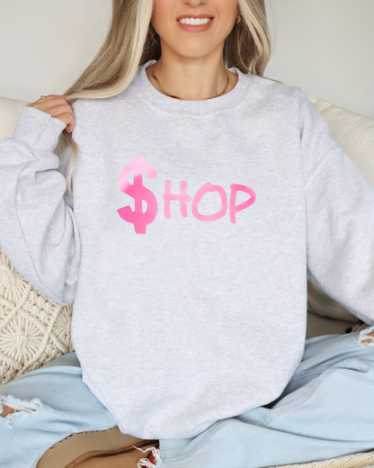 Person wearing a gray sweatshirt with pink text sitting on a couch.