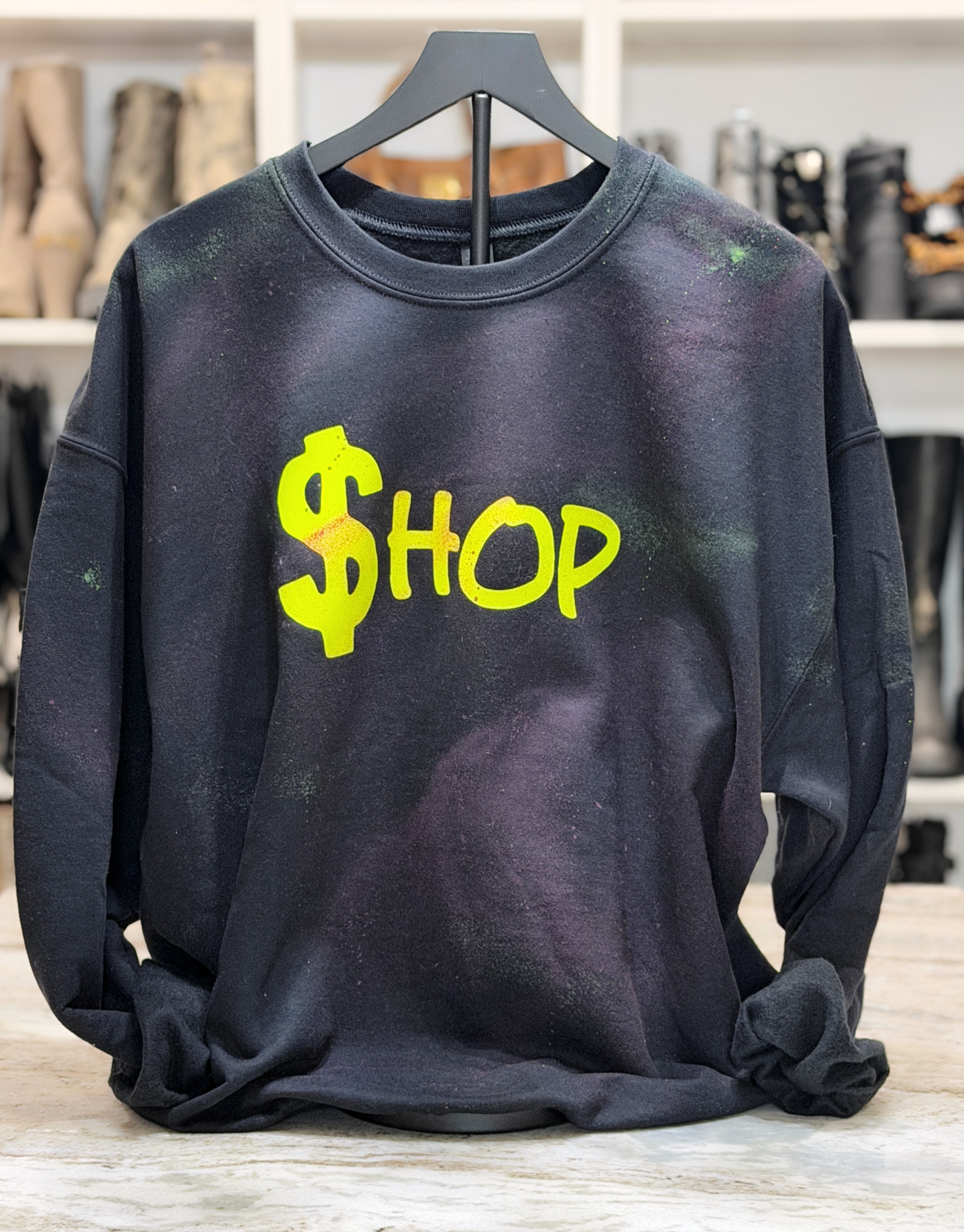 Black sweatshirt with yellow '$HOP' text on a hanger
