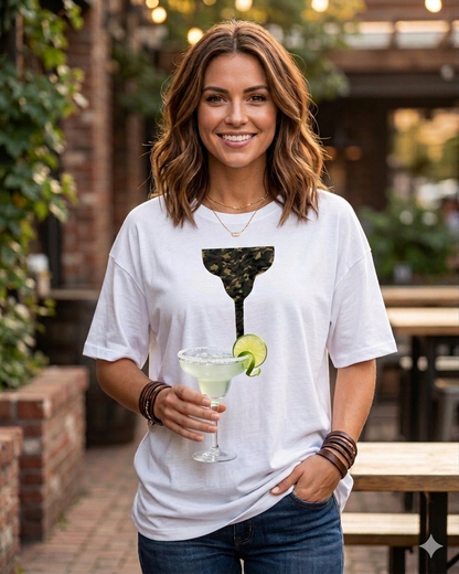 Woman wearing a white t-shirt with a cocktail graphic, holding a drink outdoors.