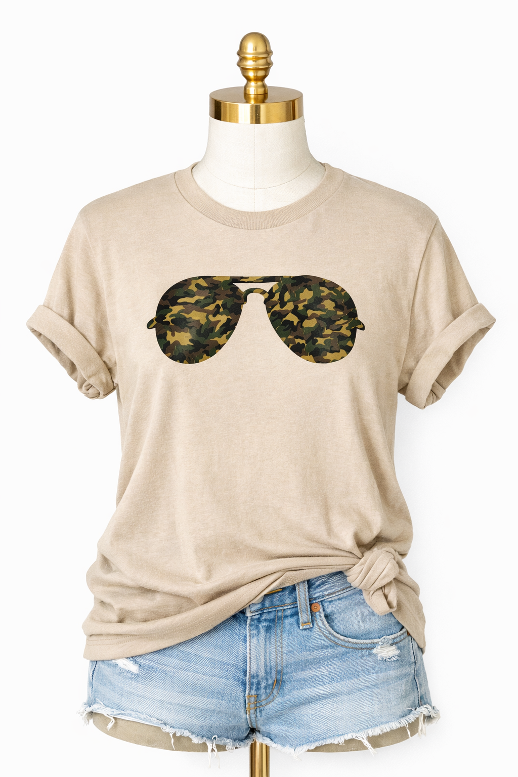 Beige t-shirt with camouflage sunglasses graphic on a mannequin with denim shorts.