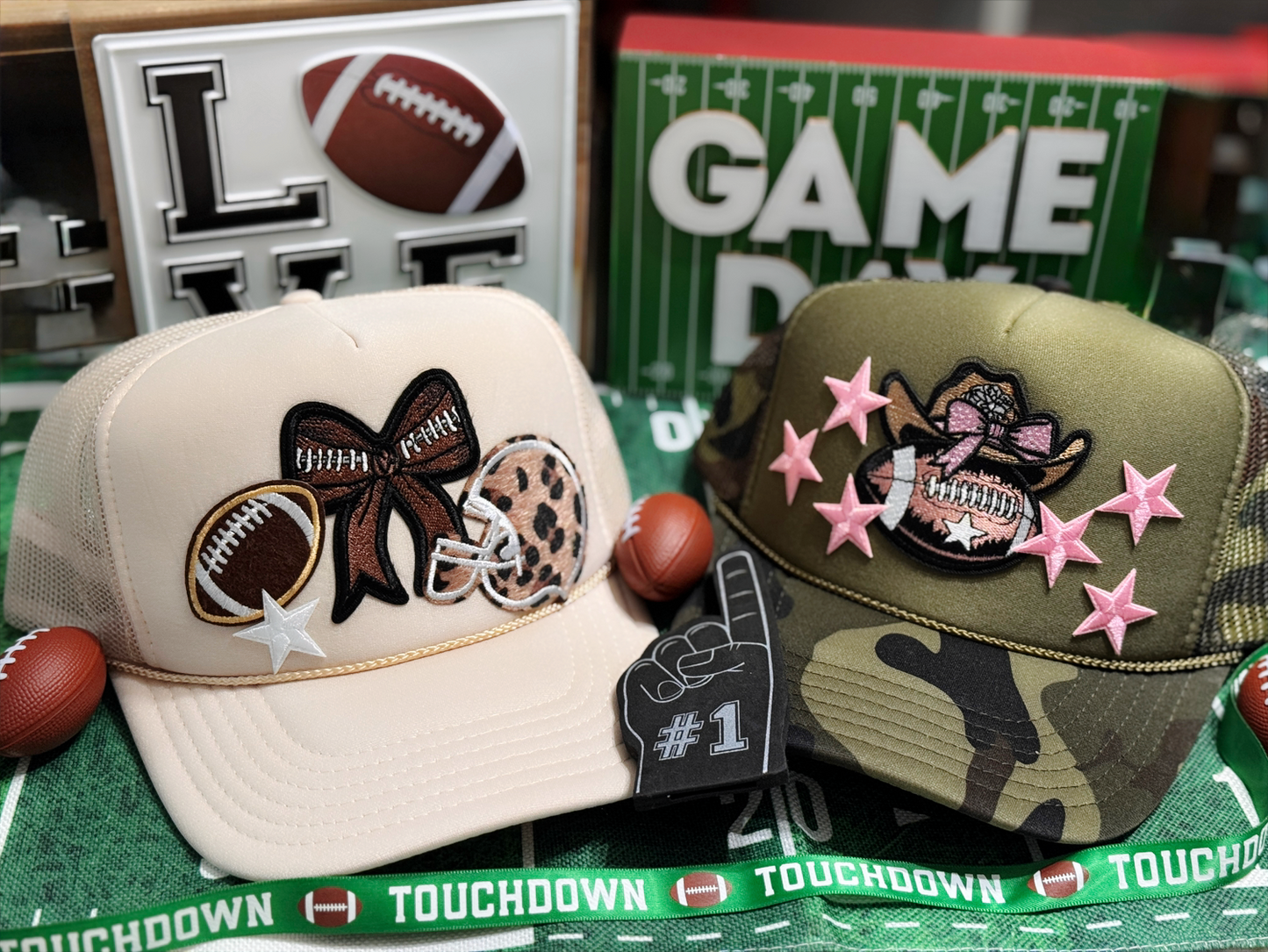 Two decorative caps with sports-themed designs on a green surface with 'Touchdown' text.