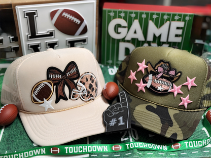Two decorative caps with sports-themed designs on a green surface with 'Touchdown' text.