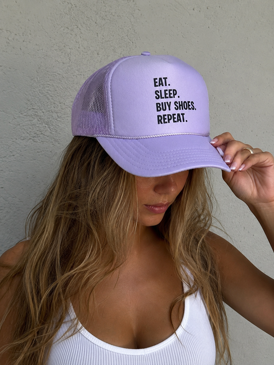 Person wearing a purple cap with text, against a plain background