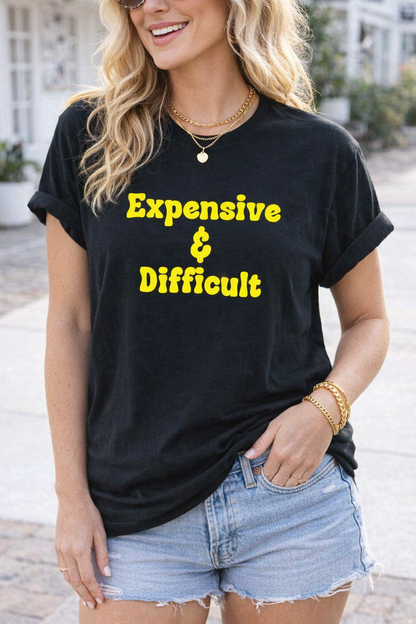Woman wearing a black t-shirt with 'Expensive & Difficult' text, standing outdoors.