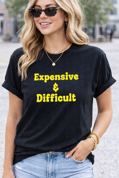 Woman wearing a black t-shirt with 'Expensive & Difficult' text in yellow.