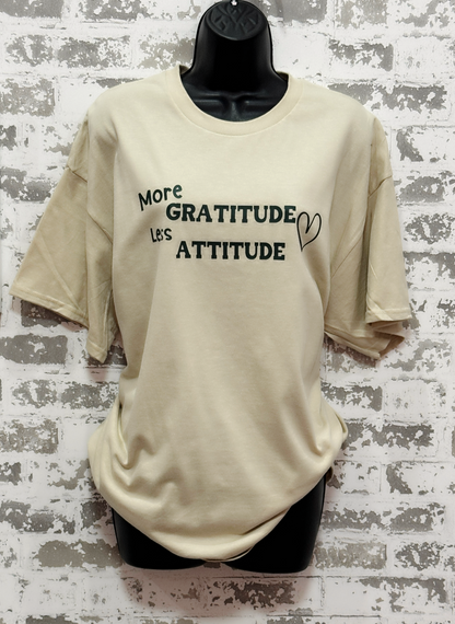 More Gratitude Less Attitude T-Shirt – Sand-Colored Tee with Green Positive Vibes Graphic