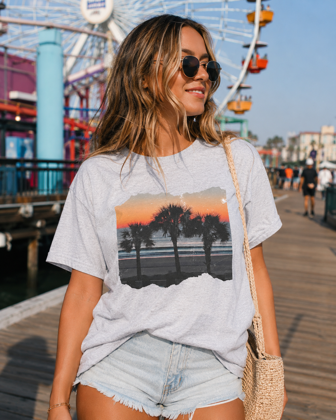 Woman wearing a t-shirt with a beach graphic in front of an amusement park.