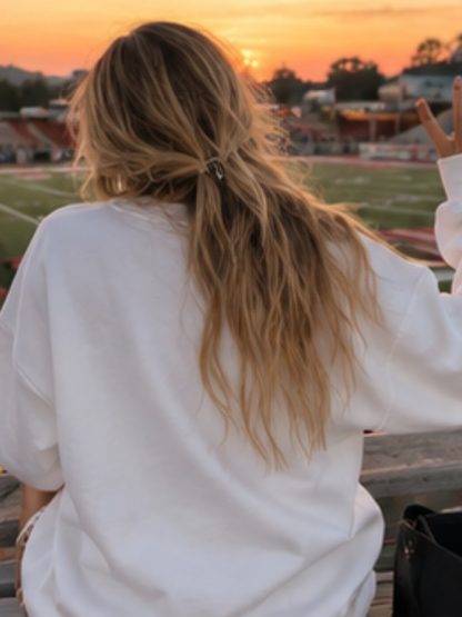 Woman wearing a sweatshirt in a stadium