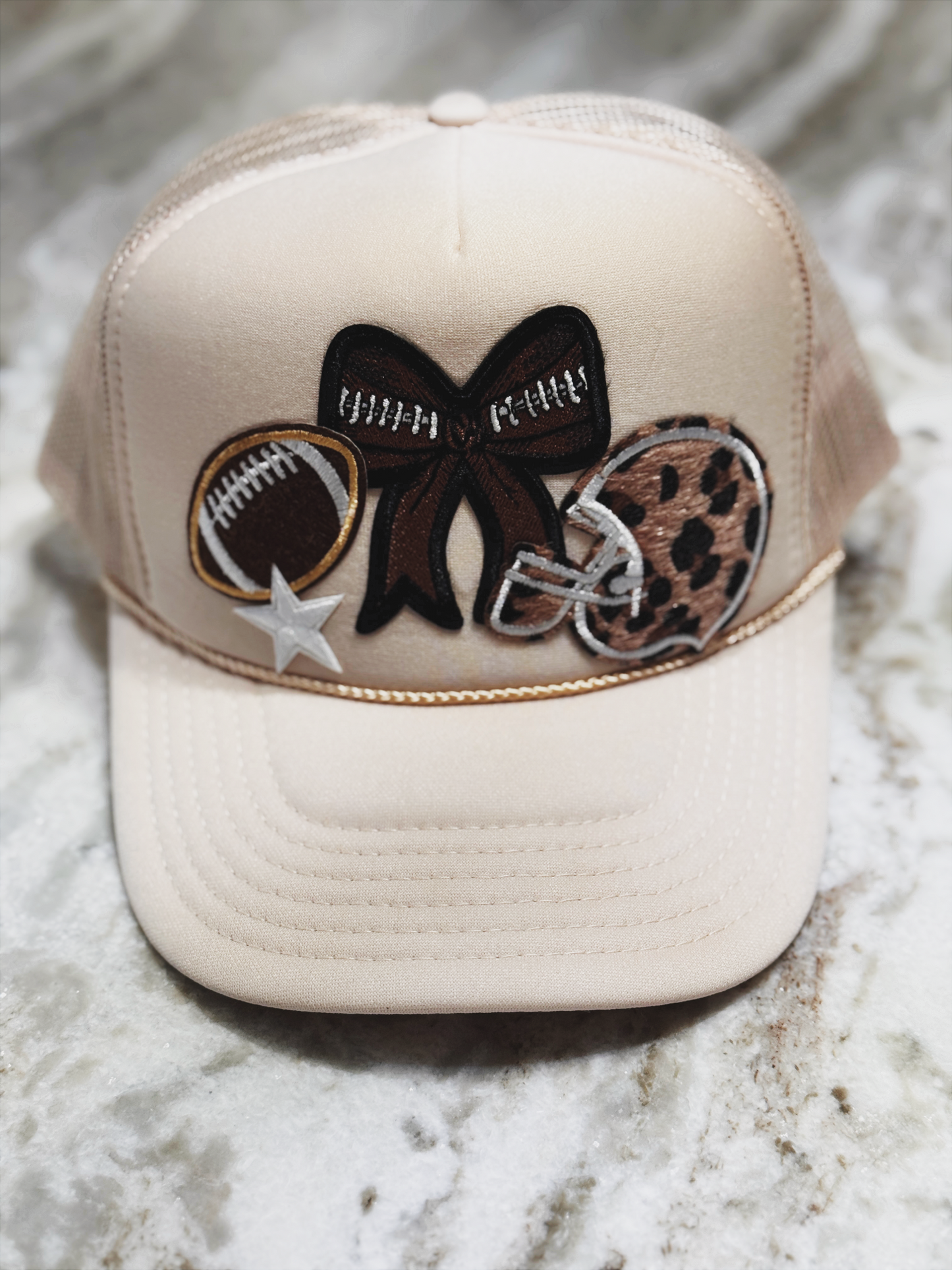 Beige cap with decorative patches on a marble surface
