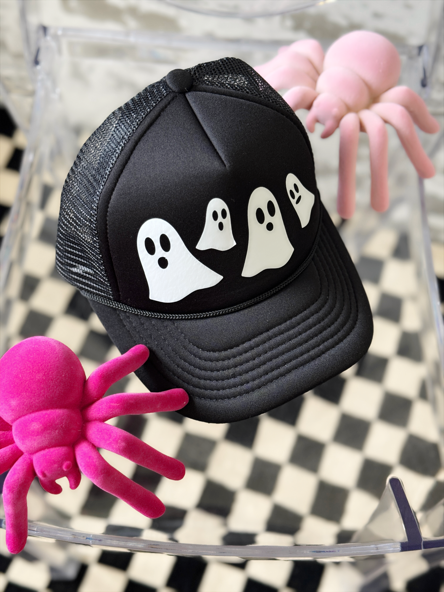 Black cap with ghost designs on a checkered background