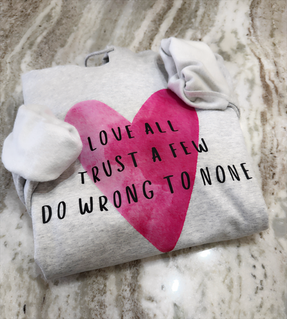 Folded hoodie with a pink heart and text on a marble surface