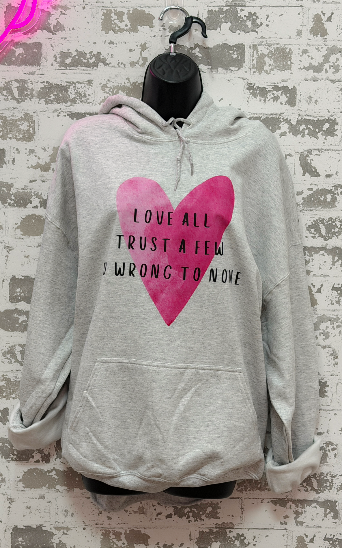 Gray hoodie with pink heart and text on a textured background