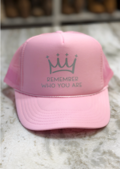 Pink cap with a crown and text design on a textured surface