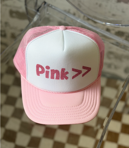 Pink and white cap with 'Pink >' text on a checkered floor background