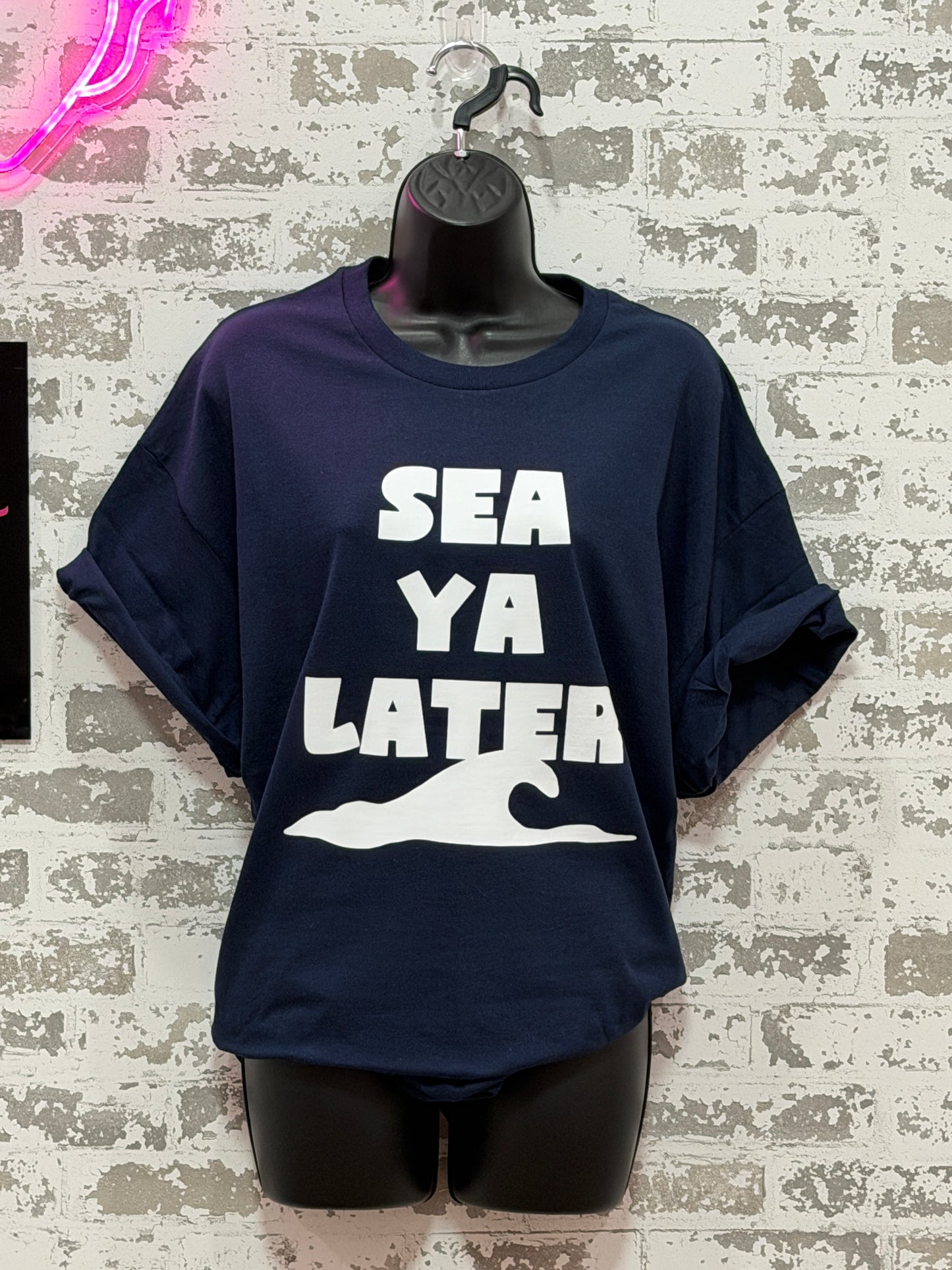 Navy blue hoodie with 'SEA YA LATER' text on a textured surface