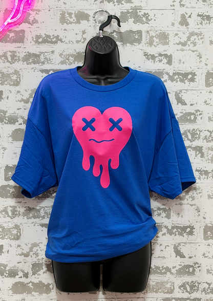 Blue t-shirt with a pink heart design on a textured wall background