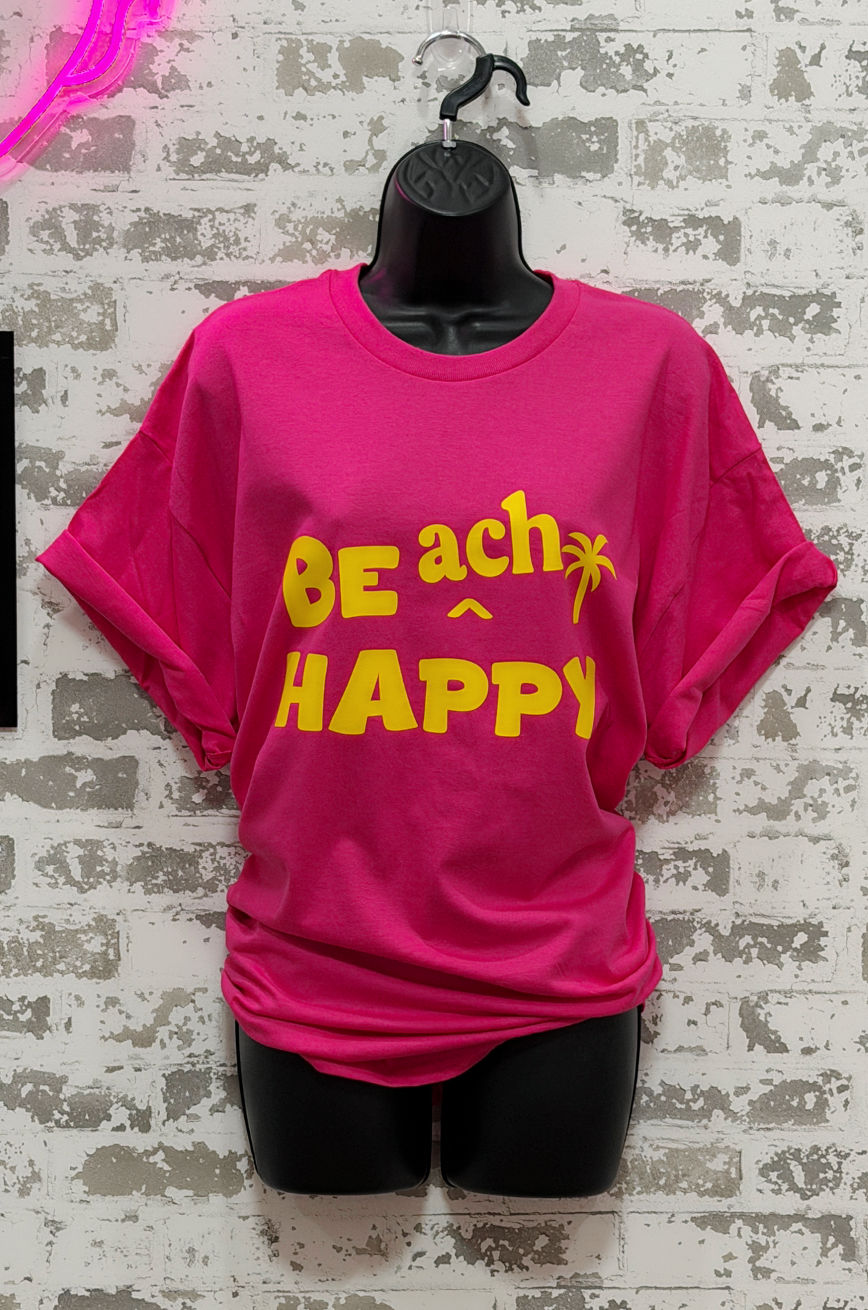  a hot pink shirt with bright yellow "BE ach HAPPY" graphic