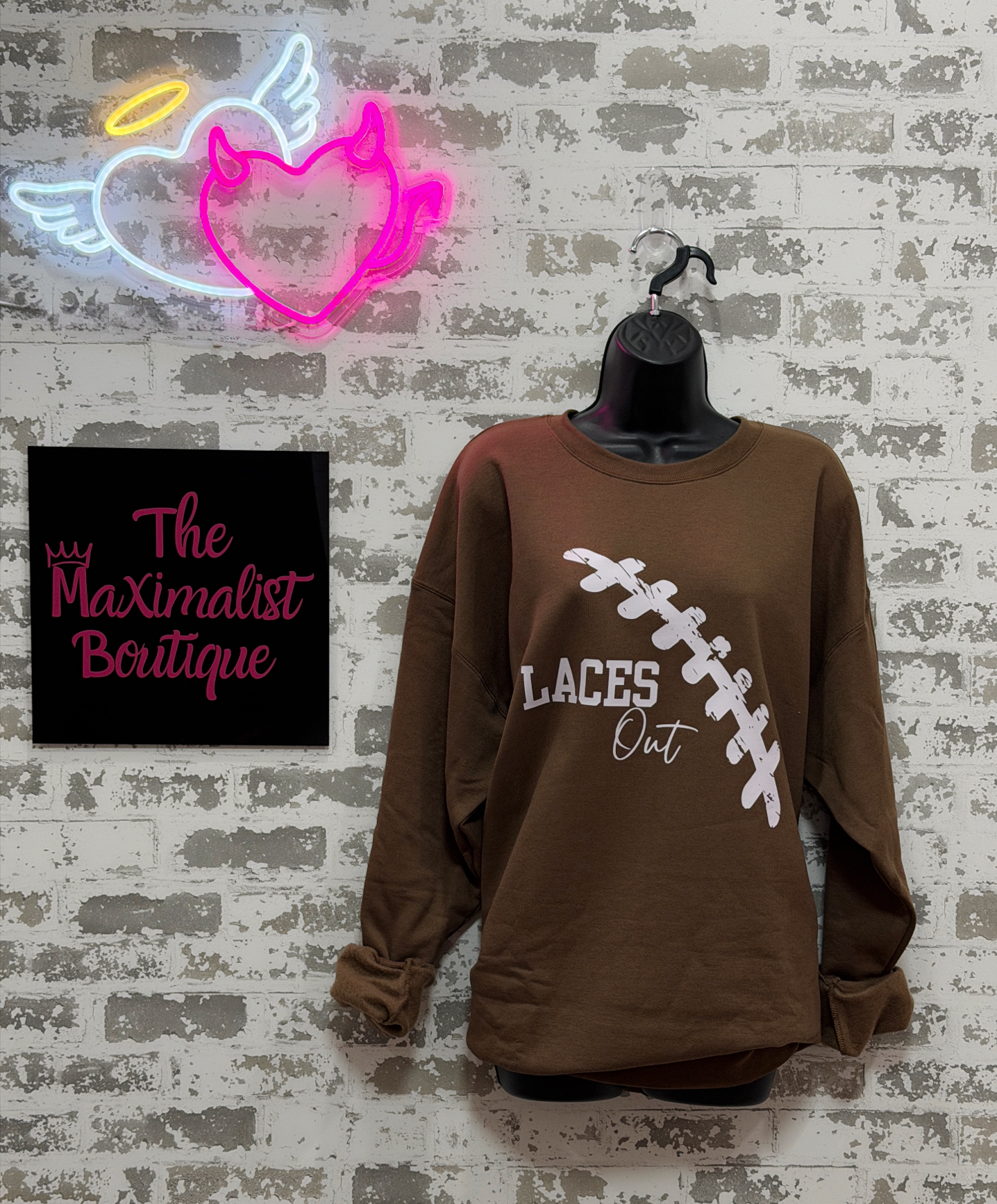  brown sweatshirt with light pink "Laces Out" football graphic 