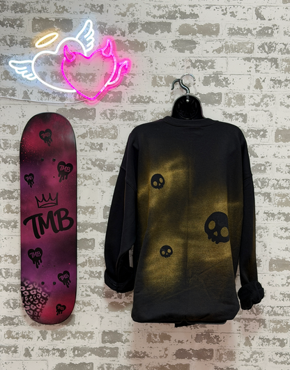 a black crewneck sweatshirt with a gold skeleton rib cage graphic and skull motifs,