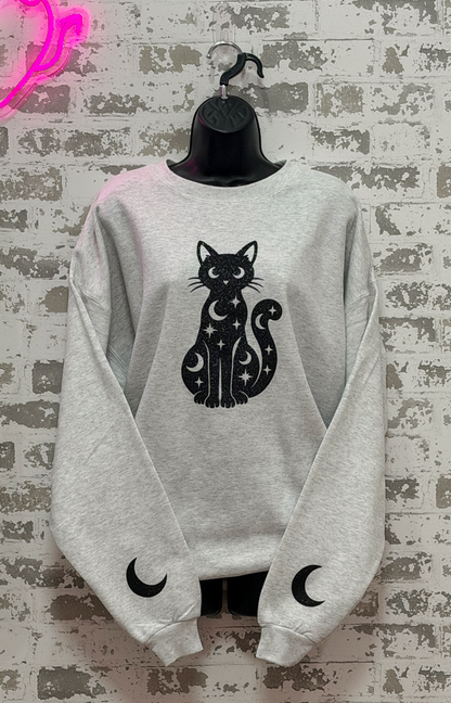 a light gray crewneck sweatshirt with a black cat and moon graphic,