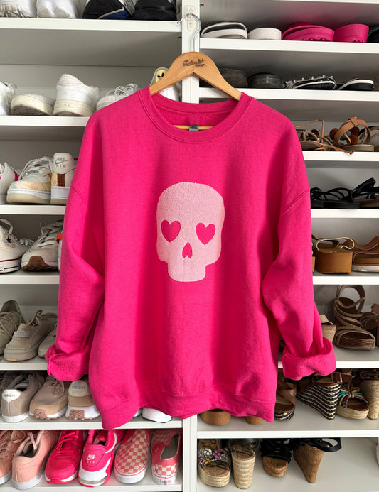 Bright pink sweatshirt with textured pink skull graphic