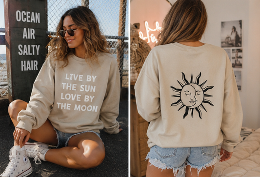 A woman modeling a cream sweatshirt in a split view: sitting outdoors on the left with the front text reading 'LIVE BY THE SUN LOVE BY THE MOON,' and standing indoors on the right showing the back with a large black sun graphic.