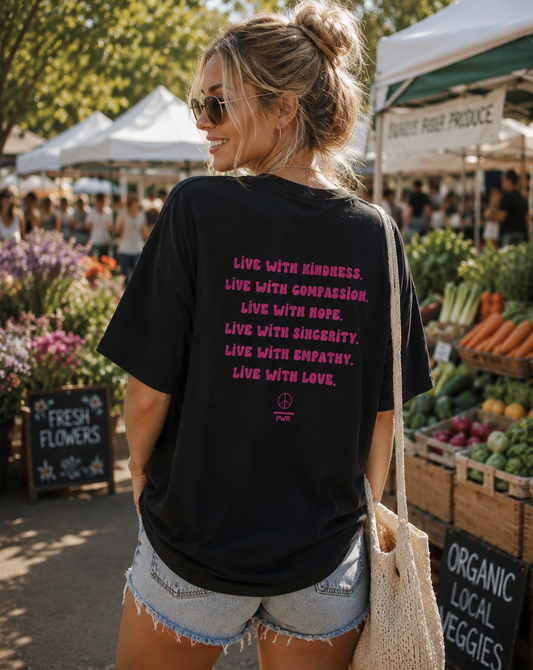 Woman at an outdoor market wearing a black t-shirt with motivational text.