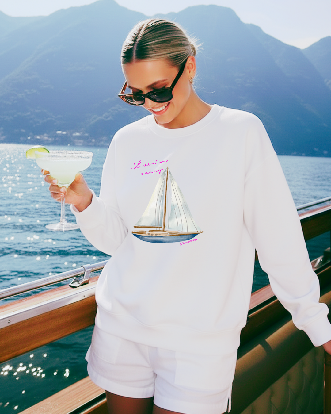 White sweatshirt featuring a sailboat illustration with the phrase “Livin’ On Vacay” across the chest
