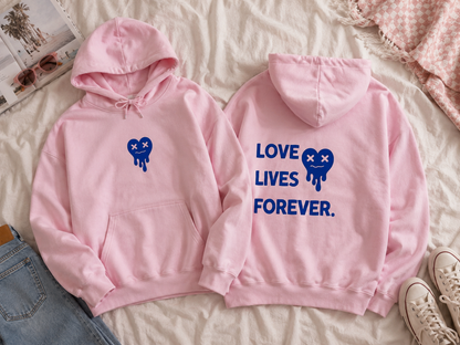 Two pink hoodies with blue designs on a light-colored surface.
