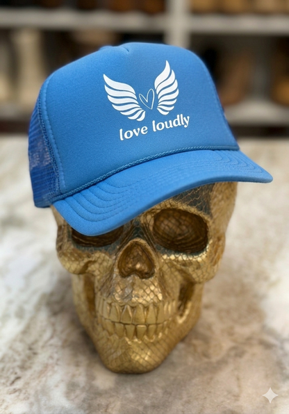 Blue cap with 'love loudly' text and logo on a gold skull
