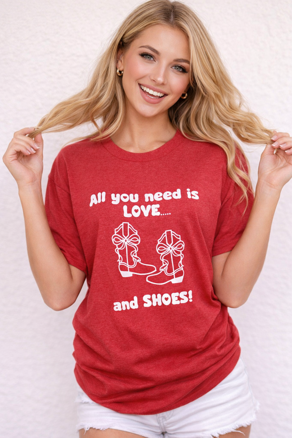 Woman wearing a red t-shirt with text and graphics, standing against a plain background