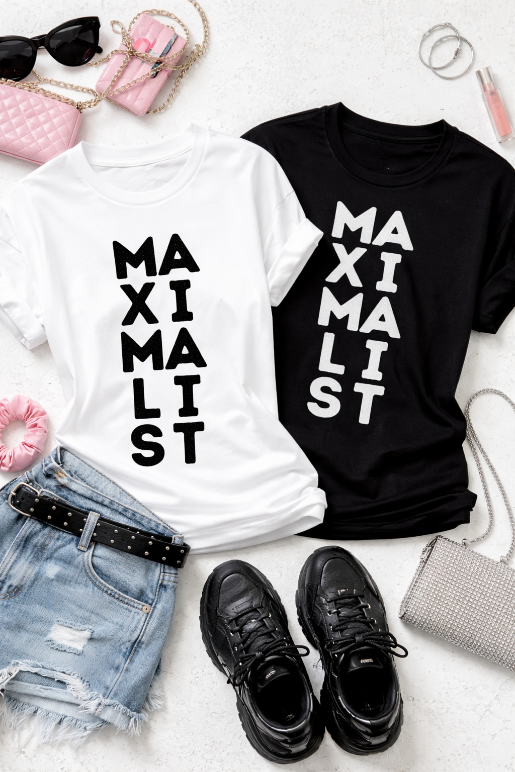 Two t-shirts, one white and one black, with 'MAXIMALIST' text, displayed with accessories on a light surface.