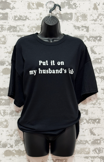 Black t-shirt with text on a mannequin against a textured wall background