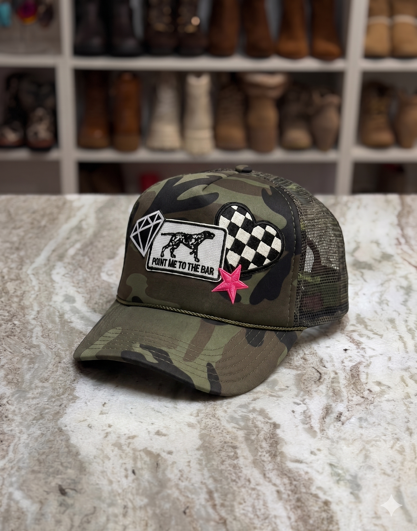 Camouflage cap with patches on a textured surface with boots in the background