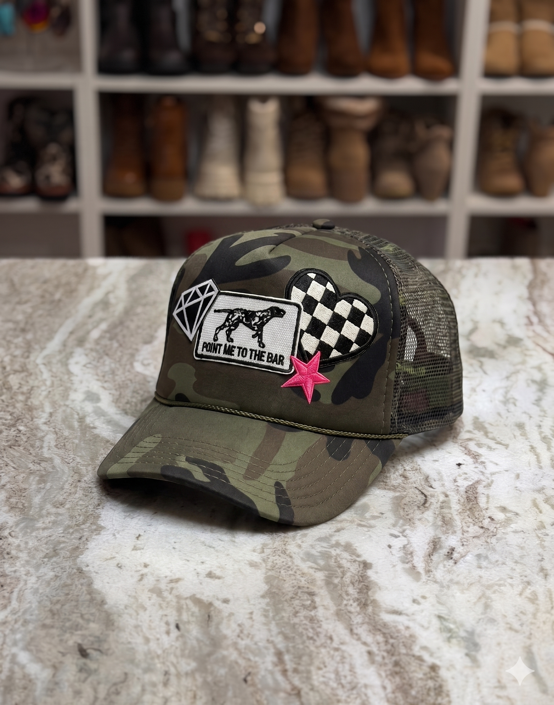 Camouflage cap with patches on a textured surface with boots in the background