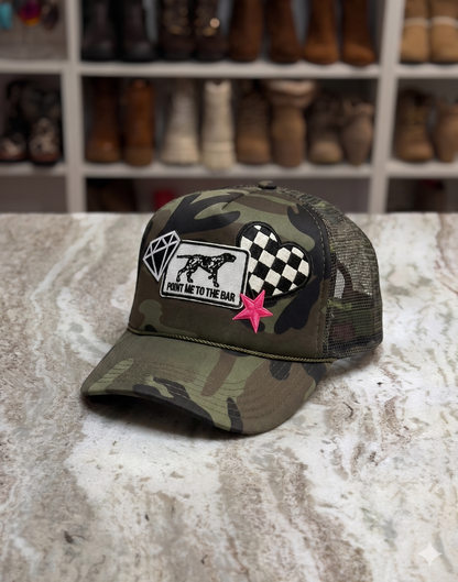 Camouflage cap with patches on a textured surface with boots in the background