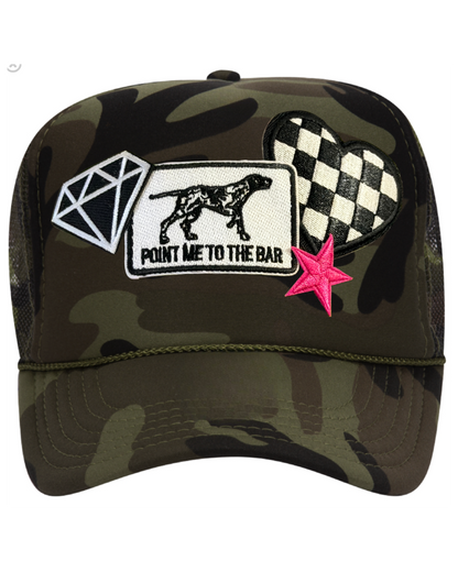 Camouflage cap with various patches including a diamond, dog, and star on a white background