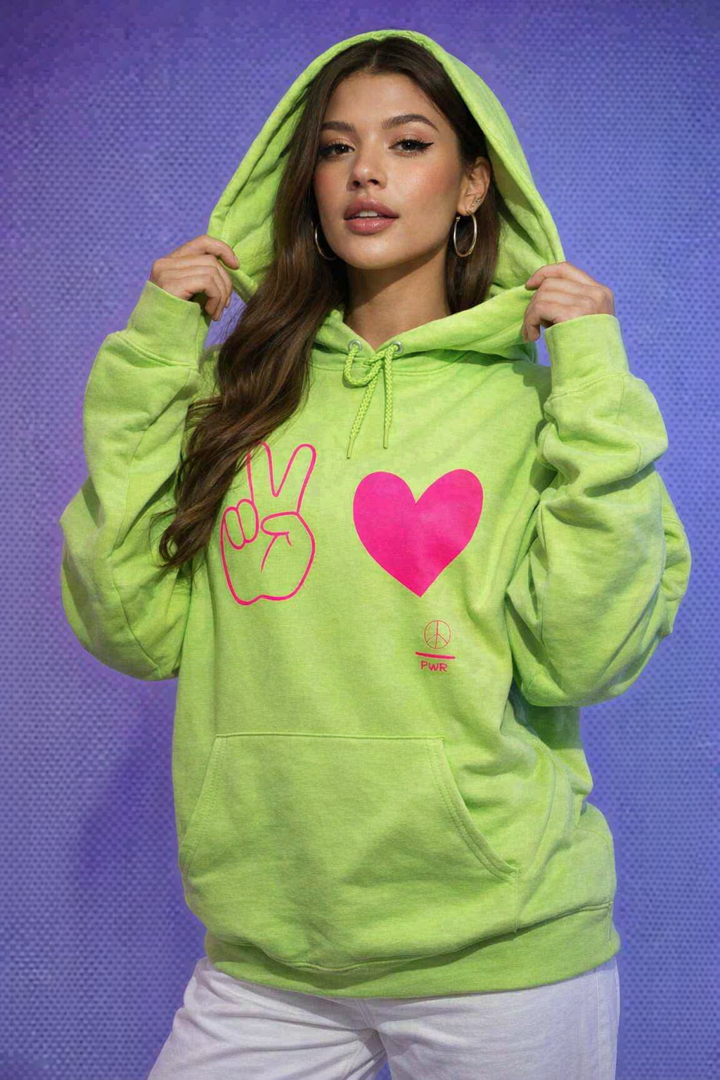 Person wearing a bright green hoodie with peace sign and heart design on a blue background