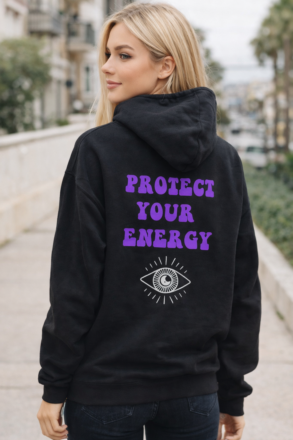 Model wearing a black hoodie with Protect Your energy graphic on back 