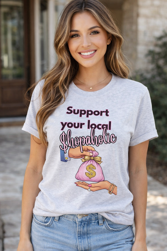 Funny “Support Your Local Shopaholic” graphic tee on ash gray.