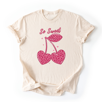 Beige t-shirt with pink leopard print cherries and 'So Sweet' text on a white background