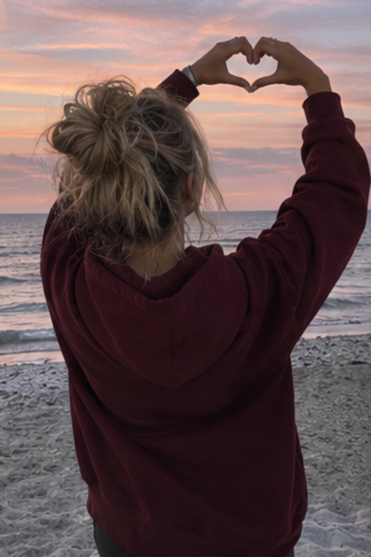 Woman wearing a maroon sweatshirt that is blank on the back
