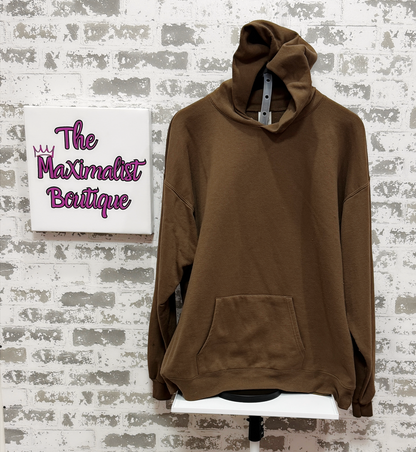Brown hoodie on a stand with 'The Maximalist Boutique' sign in the background