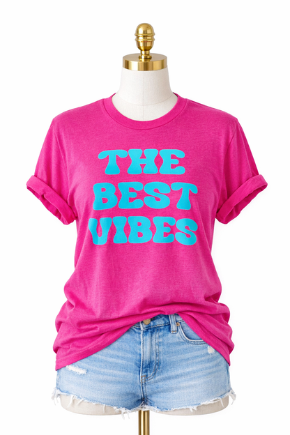 Pink t-shirt with 'THE BEST VIBES' text on a mannequin with denim shorts.
