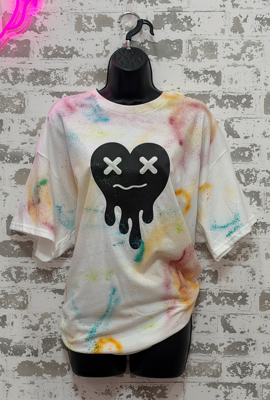 Paint splatter t-shirt with a black heart on a textured gray background