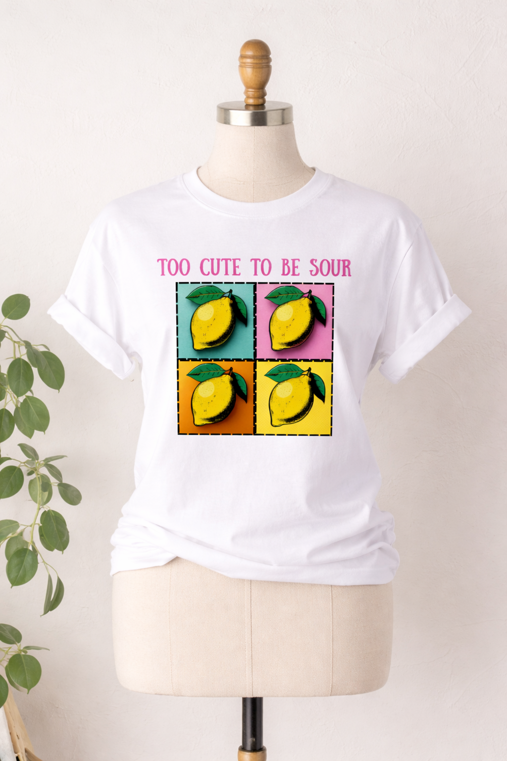 White t-shirt with lemon graphic and text on a mannequin against a white background